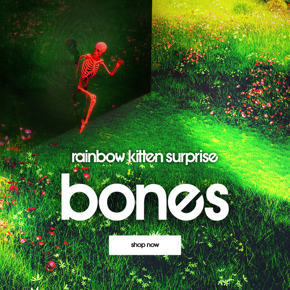 Promotional graphic with skeleton, grass, and flowers, featuring 'rainbow kitten surprise bones' text.